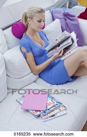 Stock Photography - Young woman with ipad and magazines . Fotosearch