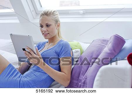 Stock Image - Young woman with ipad . Fotosearch