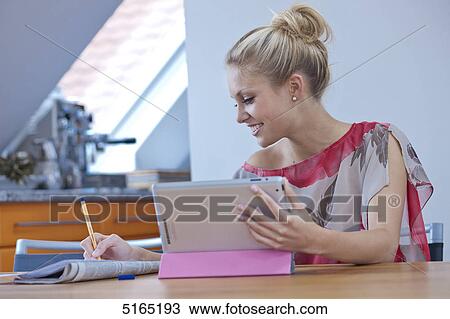 Stock Image - Young woman with ipad . Fotosearch