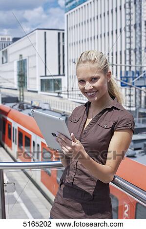 Stock Image - Young woman with ipad . Fotosearch
