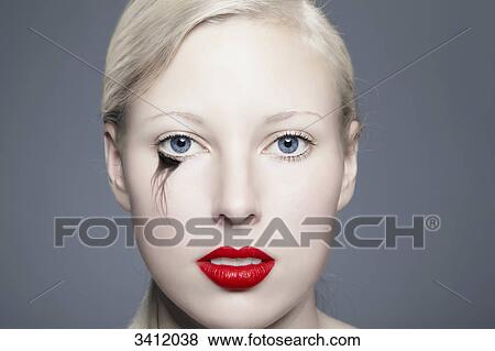 Stock Photo - Young woman with red lips and blurred eyeliner, portrait . Fotosearch