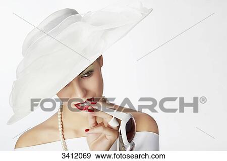 Young woman with white hat biting on sunglasses View Large Photo Image Stock Photo - Young woman with white hat biting on sunglasses . Fotosearch