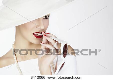 Young woman with white hat biting on sunglasses View Large Photo Image Stock Photograph - Young woman with white hat biting on sunglasses . Fotosearch