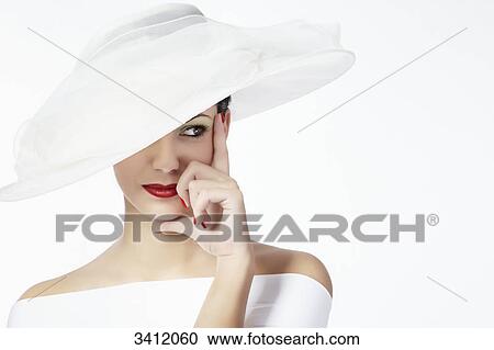 Stock Image - Young woman with white hat, portrait . Fotosearch
