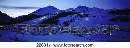 Aerial view of village on snow-covered landscape lit up at night, Arlberg, Austria View Large Photo Image Stock Photo - Aerial view of village on snow-covered landscape lit up at night, Arlberg, Austria . Fotosearch