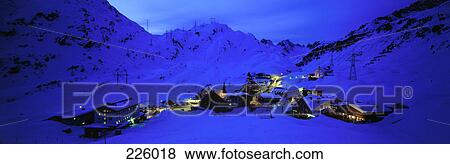 Stock Photo - Aerial view of village on snow-covered landscape lit up at night, Arlberg, Austria . Fotosearch