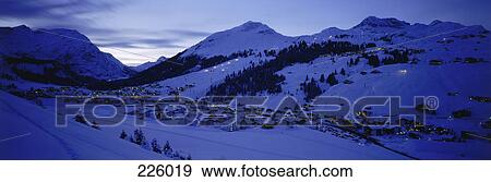 Aerial view of village on snow-covered landscape lit up at night, Arlberg, Austria View Large Photo Image Stock Photo - Aerial view of village on snow-covered landscape lit up at night, Arlberg, Austria . Fotosearch