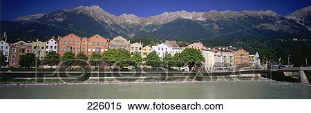Stock Photography - Apartments at waterfront with mountains in background, Innsbruck, Tyrol, Austria . Fotosearch