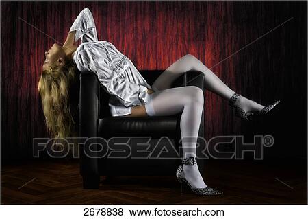 blonde woman resting on a leather chair, side vview View Large Photo Image Stock Photo - blonde woman resting on a leather chair, side vview . Fotosearch
