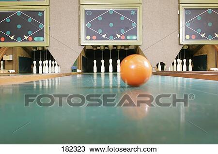 Stock Image - Bowling ball and pins in bowling alley . Fotosearch