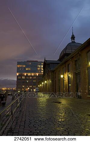 Stock Image - Buildings lit up at dusk, Fischauktionshalle, Altona, Hamburg, Germany . Fotosearch