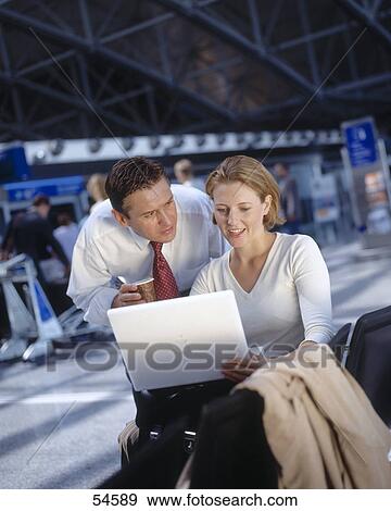 Stock Photo - Businessman and businesswoman looking at laptop . Fotosearch