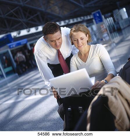 Businessman and businesswoman looking at laptop View Large Photo Image Stock Photograph - Businessman and businesswoman looking at laptop . Fotosearch