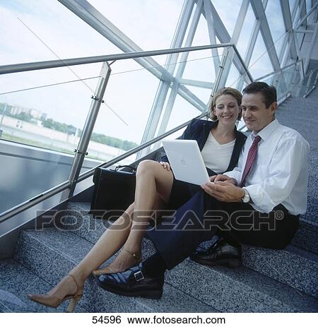 Businessman and businesswoman looking at laptop and smiling View Large Photo Image Stock Photograph - Businessman and businesswoman looking at laptop and smiling . Fotosearch