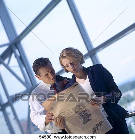 Businessman and businesswoman reading newspaper View Large Photo Image Stock Image - Businessman and businesswoman reading newspaper . Fotosearch