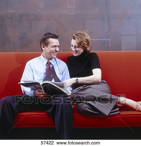 Businessman and businesswoman smiling on couch View Large Photo Image Stock Image - Businessman and businesswoman smiling on couch . Fotosearch