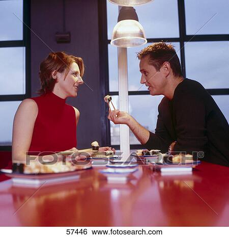 Stock Photograph - Businessman and businesswoman talking to each other in bar . Fotosearch