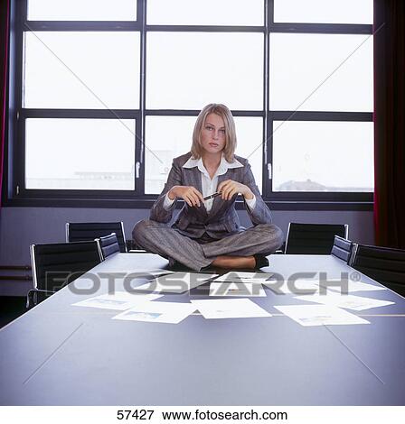 Stock Photo - Businesswoman sitting on table . Fotosearch