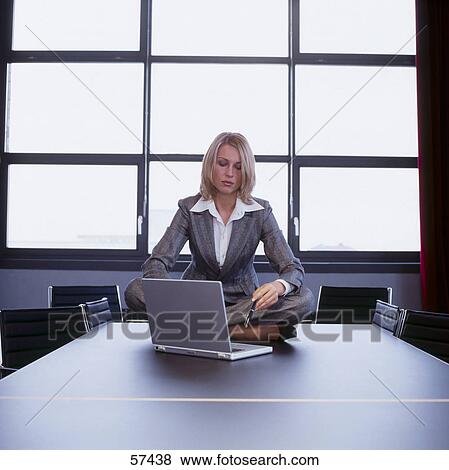 Businesswoman sitting with laptop at a conference table View Large Photo Image Stock Photo - Businesswoman sitting with laptop at a conference table . Fotosearch