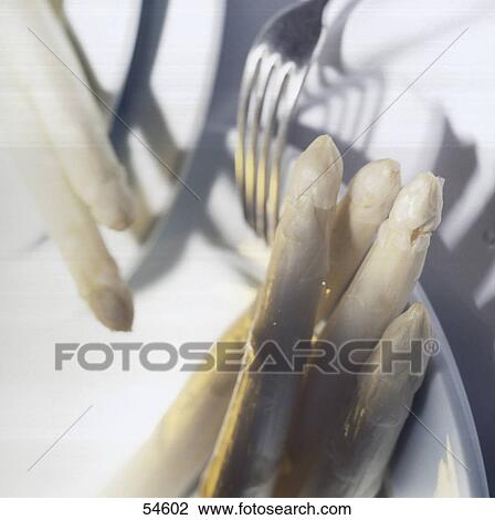Stock Image - Close-up of asparagus with fork on plate . Fotosearch