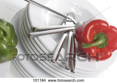 Picture - Close-up of red bell pepper and table knives on stack of plates . Fotosearch