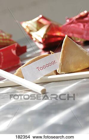Picture - Close-up of tor fortune sticking out of fortune cookie . Fotosearch