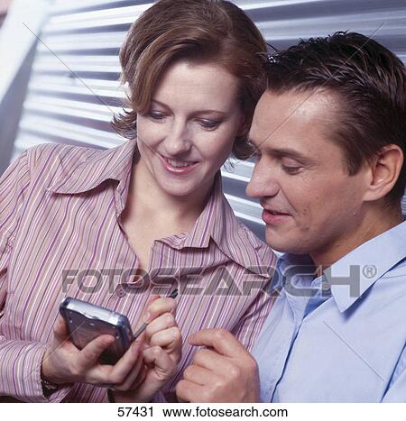 Close-up of two businesspeople using personal organizer View Large Photo Image Stock Image - Close-up of two businesspeople using personal organizer . Fotosearch