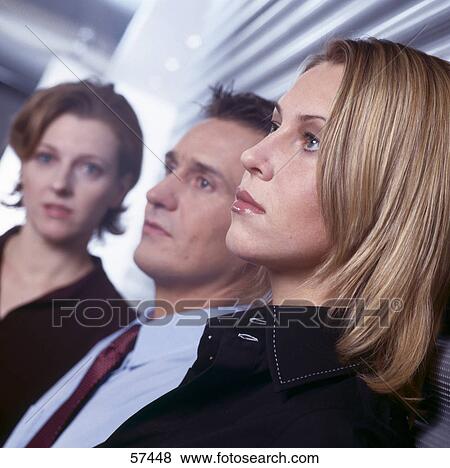 Close-up of two businesswomen and businessman standing in row View Large Photo Image Stock Photo - Close-up of two businesswomen and businessman standing in row . Fotosearch