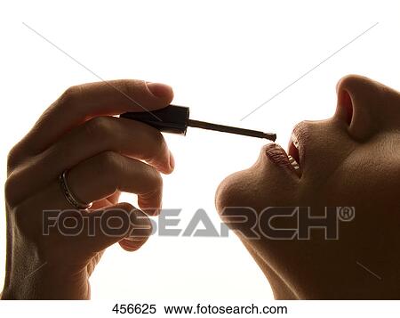 Close-up of woman applying lipstick View Large Photo Image Stock Photography - Close-up of woman applying lipstick . Fotosearch