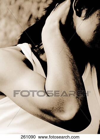Stock Image - Close-up of woman with her hands in her hair . Fotosearch