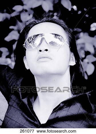 Close-up of young man wearing sunglasses View Large Photo Image Stock Photo - Close-up of young man wearing sunglasses . Fotosearch
