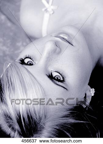 Stock Photo - Close-up of young woman lying on floor . Fotosearch