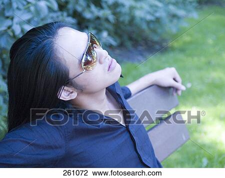 Close-up of young woman thinking in park View Large Photo Image Stock Image - Close-up of young woman thinking in park . Fotosearch