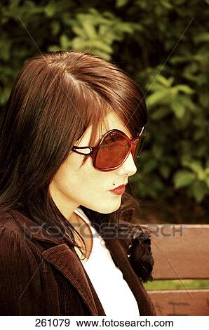 Stock Photo - Close-up of young woman wearing sunglasses . Fotosearch