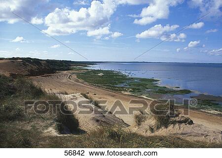 Stock Image - Clouds in the sky above a coastline . Fotosearch