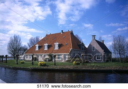 Stock Image - Farmhouse in field, Friesland, Netherlands . Fotosearch