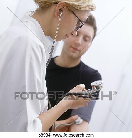 Picture - Female doctor checking man's blood pressure . Fotosearch