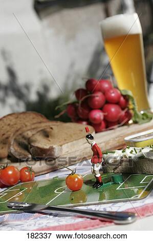 Stock Photo - Figurine of soccer player and tomato . Fotosearch