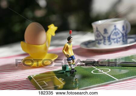 Stock Photography - Figurine of soccer player on toy field at breakfast table . Fotosearch
