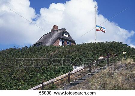 Stock Photo - Flag on half-mast in front of a house . Fotosearch