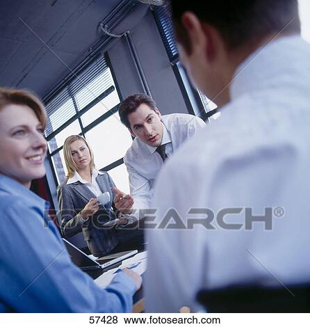 Stock Photo - Four businesspeople discussing in a meeting . Fotosearch