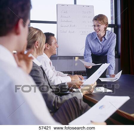 Stock Image - Four businesspeople smiling in a meeting . Fotosearch
