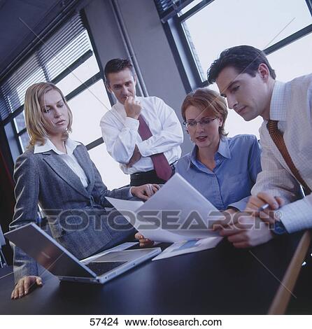 Four employees having a meeting View Large Photo Image Picture - Four employees having a meeting . Fotosearch