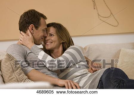 Happy couple embracing on couch View Large Photo Image Stock Photography - Happy couple embracing on couch . Fotosearch