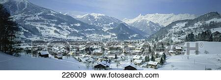 Stock Photo - Houses on snow covered landscape with mountain range in background, Zimba, Ratikon, Vorarlberg, Austria . Fotosearch