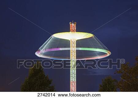 Lit up carousel in motion at amusement park during dusk View Large Photo Image Picture - Lit up carousel in motion at amusement park during dusk . Fotosearch