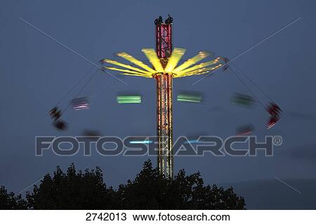 Lit up carousel in motion at amusement park during dusk View Large Photo Image Stock Image - Lit up carousel in motion at amusement park during dusk . Fotosearch