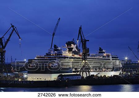 Stock Photograph - Lit up shipbuilding yard at dusk, Hamburg, Germany . Fotosearch
