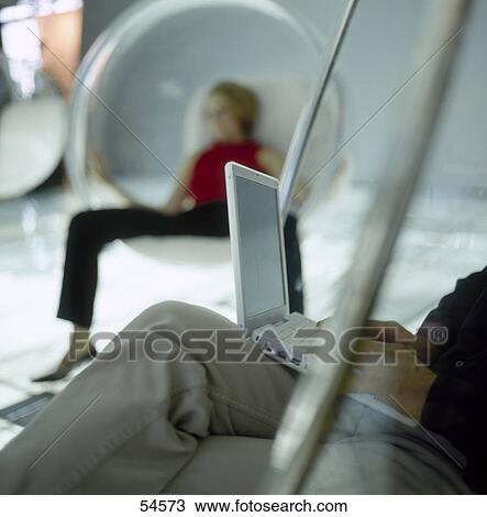 Low section view of businessman using laptop with woman in background View Large Photo Image Stock Image - Low section view of businessman using laptop with woman in background . Fotosearch