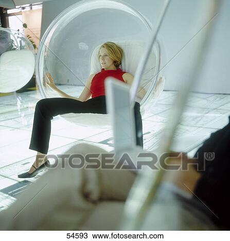 Stock Image - Low section view of businessman using laptop with young woman in background . Fotosearch